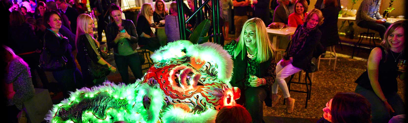 People in an establishment watching a Chinese Lion dance.