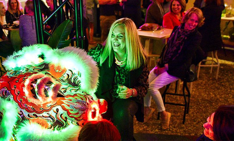 People in an establishment watching a Chinese Lion dance.