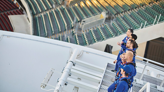 Several people participating in the Roof Climb on top of the Adelaide Oval grandstand.
